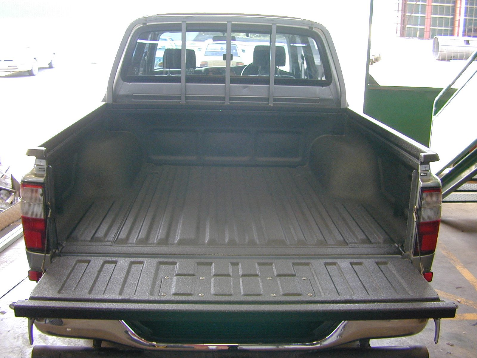 Open utility trailer deck coated with Flak Jacket polyurea
