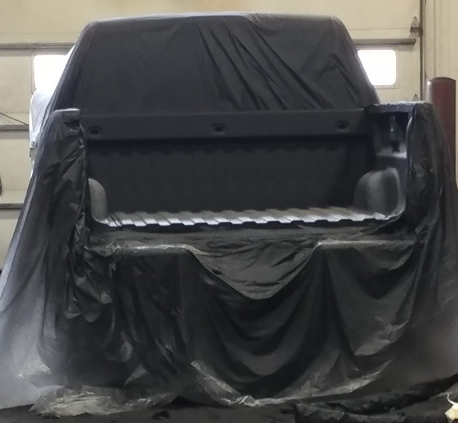 Applicator spraying polyurea coating on a trailer